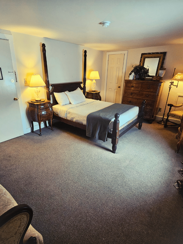 The Cedar Creek Room at The Historic Wayside Inn 1797, featuring a classic double bed and 18th-century antique furniture in Middletown, VA.