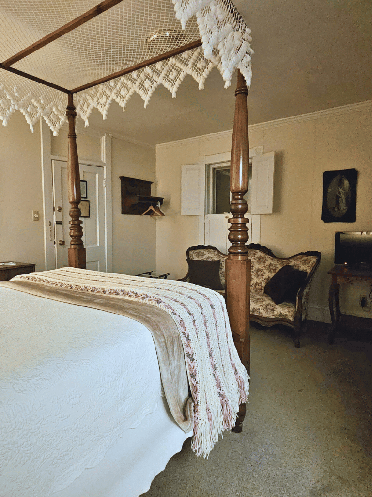 The Hite Room (Room 21) at The Historic Wayside Inn 1797 in Middletown, VA, featuring a four-poster double bed and a private bathroom with a walk-in shower.