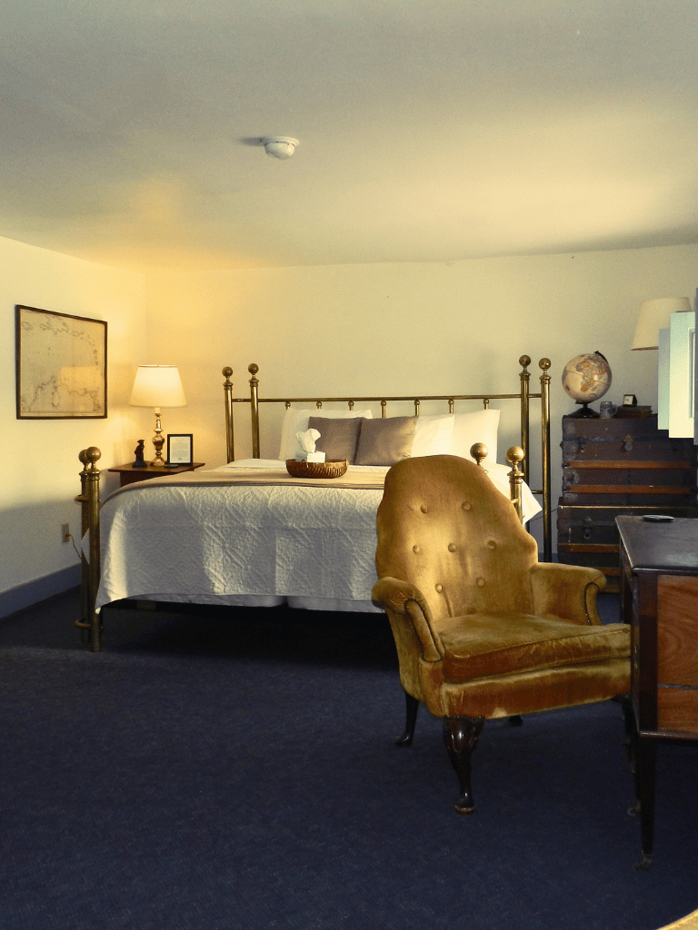 King-size bed in the historic Lincoln Room at The Historic Wayside Inn 1797, featuring period-authentic antiques and 19th-century decor in Middletown, VA.